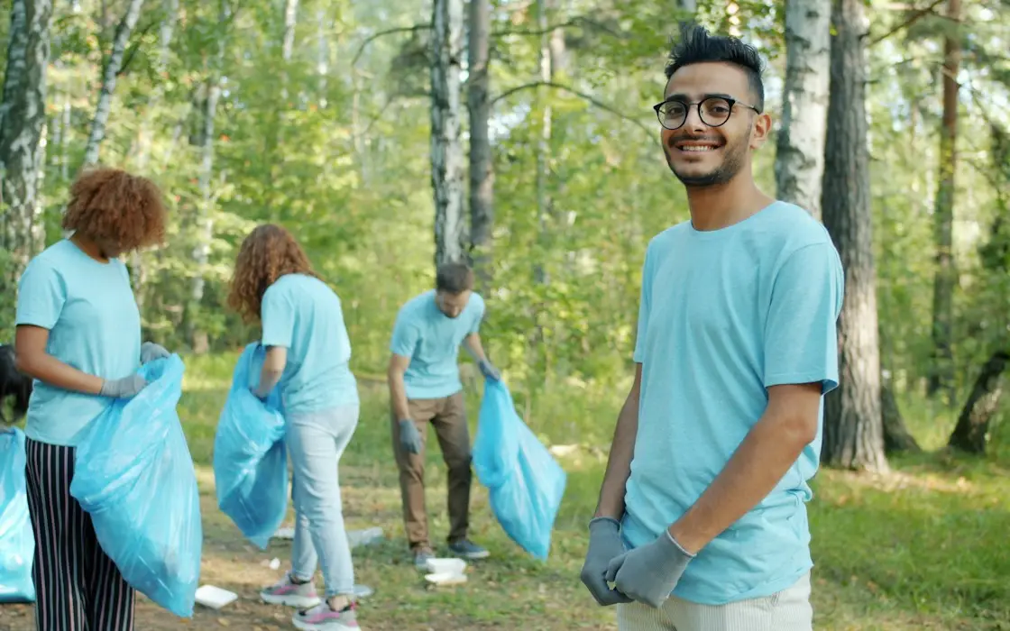 Volunteers in matching shirts cleaning up a wooded park