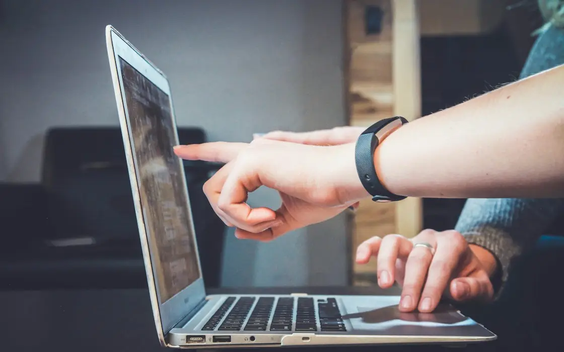 Two people pointing at a laptop screen while reviewing results